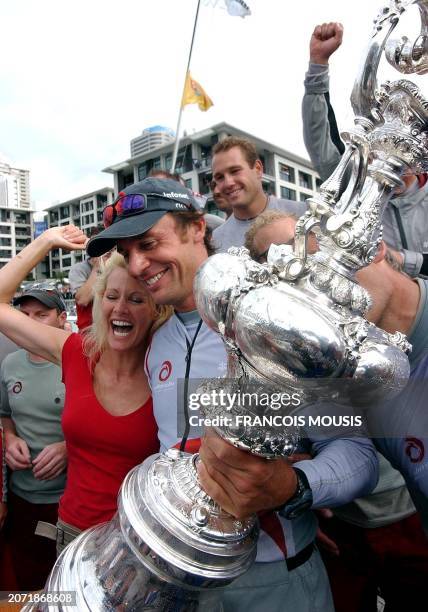 Swiss Alinghi head syndicate Ernesto Bertarelli walks with his wife Kirsty as he holds the America's Cup trophy after winning against Team New...