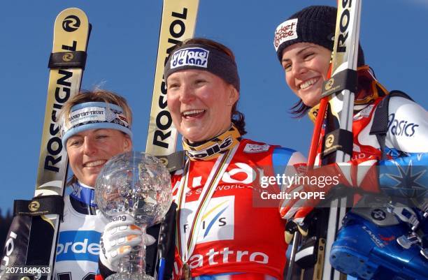 French Carole Montillet with the crystal globe trophy celebrates on the podium after winning the overall World Cup super-G competition on Thursday,...