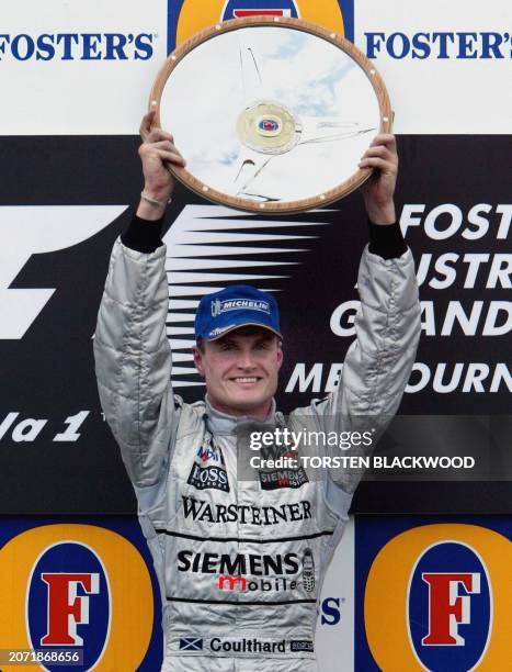 Race winner David Coulthard of Scotland displays his trophy on the podium after the Australian Formula One Grand Prix in Melbourne, 09 March 2003....