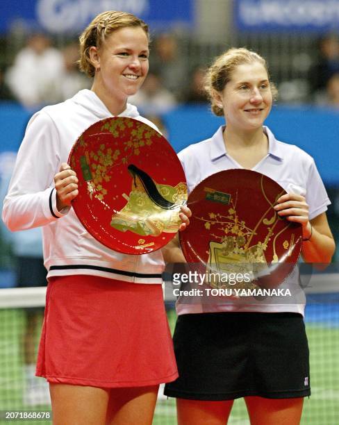 Lindsay Davenport of the US and compatriot Monica Seles hold their respective trophies during an awards ceremony following their final match against...