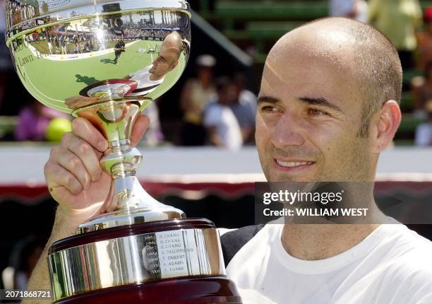 Andre Agassi of the US holds the trophy aloft after defeating Frenchman Sebastien Grosjean in the final of the Kooyong Classic, played in Melbourne...