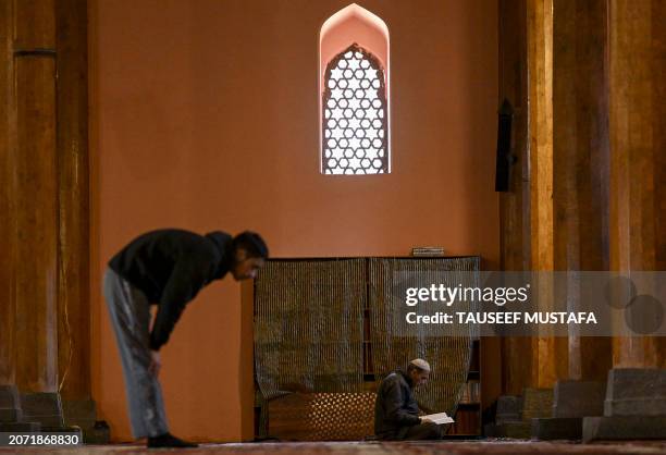 Muslim devotee reads the Koran, the holy book of Islam, on the first day of the holy fasting month of Ramadan at the Jamia Masjid in downtown...