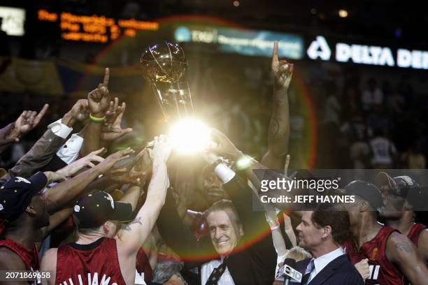 Light is reflected off the Larry O'Brian trophy as Miami Heat head coach Pat Riley and the Heat celebrate winning Game Six of the NBA Finals 95-92...