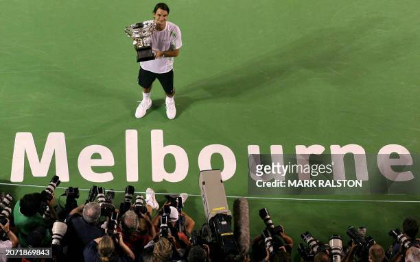 Switzerland's Roger Federer poses with the trophy after defeating Cyprus' Marcos Baghdatis after the Australian Open tennis tournament final match in...