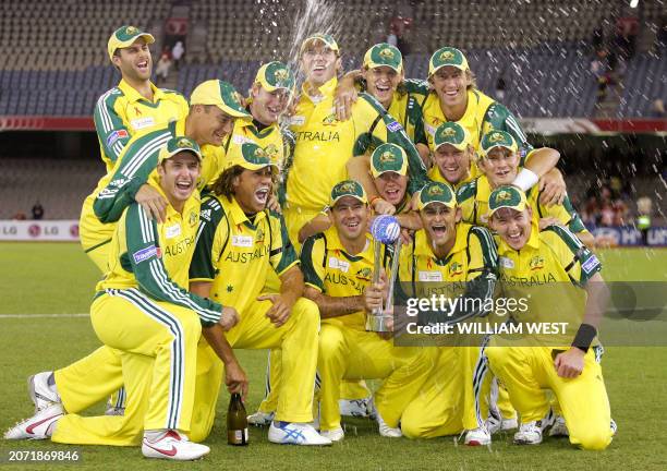 The champagne flies as the Australian team celebrate with the trophy after defeating the International Cricket Council World XI team in the third one...