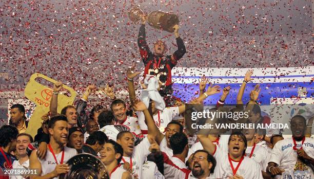 Sao Paulo's captain Rogerio Ceni , surrounded by teammmates, holds the Libertadores Cup trophy after winning the final against Atletico Paranaense,...