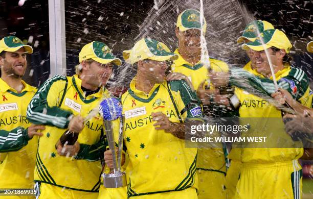 The champagne flies as Australian captain Ricky Ponting holds the trophy after defeating the International Cricket Council World XI team in the third...
