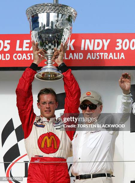 World champion Sebastien Bourdais of France and Carl Haas , owner of the Newman-Haas Racing team, display the Vanderbilt Cup on the podium after...