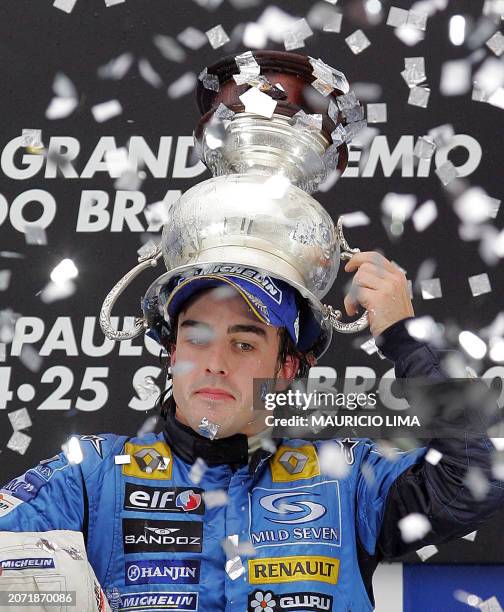 Spanish Formula One driver Fernando Alonso of Renault puts on his head the World Champion trophy obtained after arriving third in the Brazilian GP,...