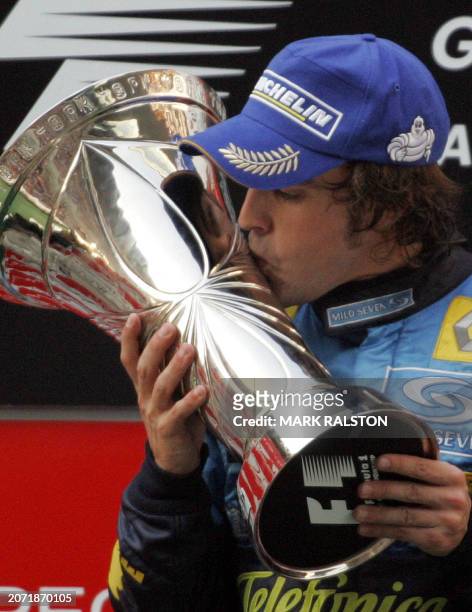 Spanish formula one driver Fernando Alonso from the Renault team, kisses the trophy on the podium after winning the Chinese Grand Prix, at the...