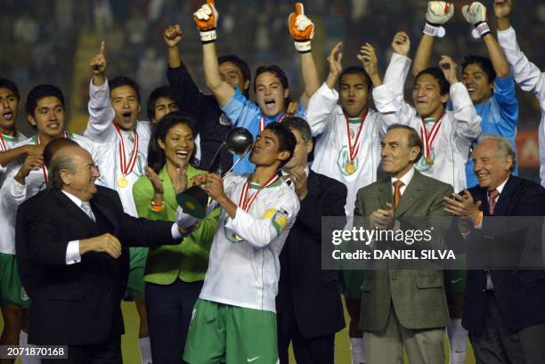 Mexican soccer player Patricio Araujo kisses the FIFA U17 World Cup championship trophy while FIFA's President Joseph Blatter looks on, in Lima, 02...