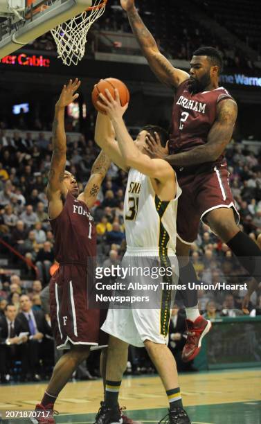 Siena's Brett Bisping is double guarded by Fordham's Mandell Thomas, left, and Tavion Leonard during a basketball game at the Times Union Center on...