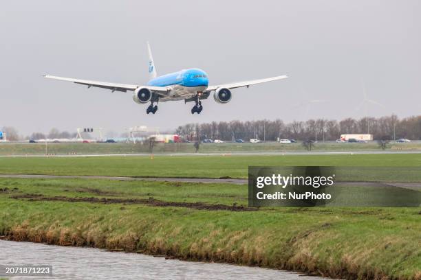 Royal Dutch Airlines Boeing 777 passenger aircraft seen arriving, in the air flying on final approach, landing and taxiing at Polderbaan runway of...