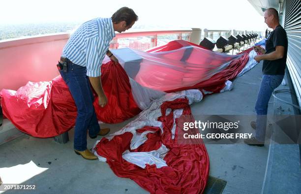 Joe Andersen and Bill Andersen unfold a 180' x 127 ' American flag on top of the Salt Lake Olympic Committee's 24 story building in downtown Salt...