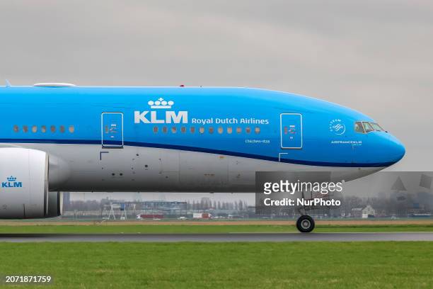 Royal Dutch Airlines Boeing 777 passenger aircraft seen arriving, in the air flying on final approach, landing and taxiing at Polderbaan runway of...