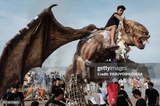 Balinese Hindu tries to cut off the head of Ogoh-ogoh, a statue symbolising an evil spirit, which was paraded ahead of Nyepi, the Day of Silence that...