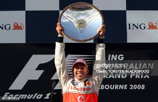 Britain's Lewis Hamilton celebrates on the podium with the winner's trophy after his McLaren won the Australian Formula One Grand Prix in Melbourne...