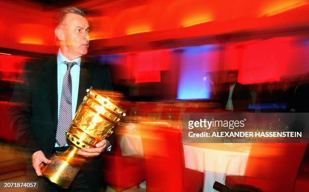 Bayern Munich's coach Ottmar Hitzfeld holds the German Cup trophy on early April 20, 2008 during the Bayern Munich party after they defeated Borussia...