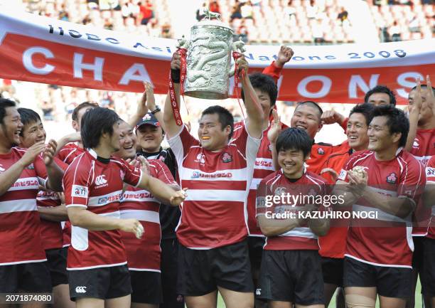 Japan's national rugby team celebrate with the championship trophy for the Asian Five Nations rugby tournament during the awards ceremony after their...