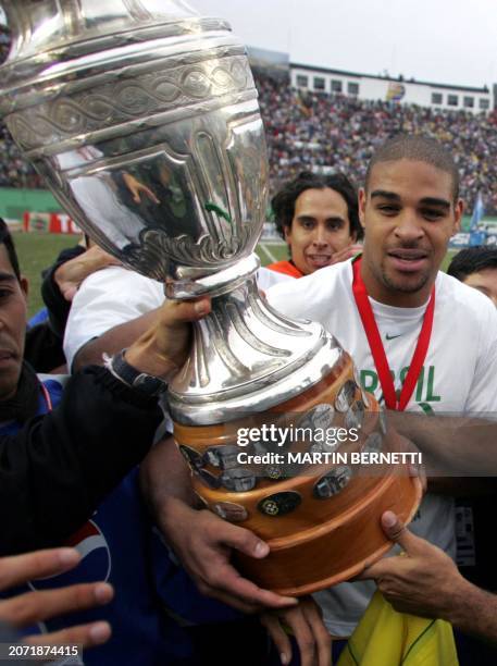Brazil's forward and striker Adriano Ribeiro holds the Copa America 2004 trophy, 25 July 2004, after defeating Argentina in the final match at the...