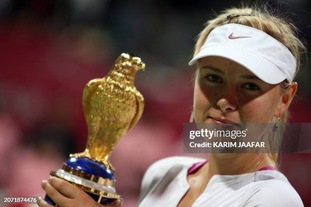 Maria Sharapova of Russia poses with her trophy after winning the final tennis match of the 2.5 million US dollar Qatar Open WTA tournament against...