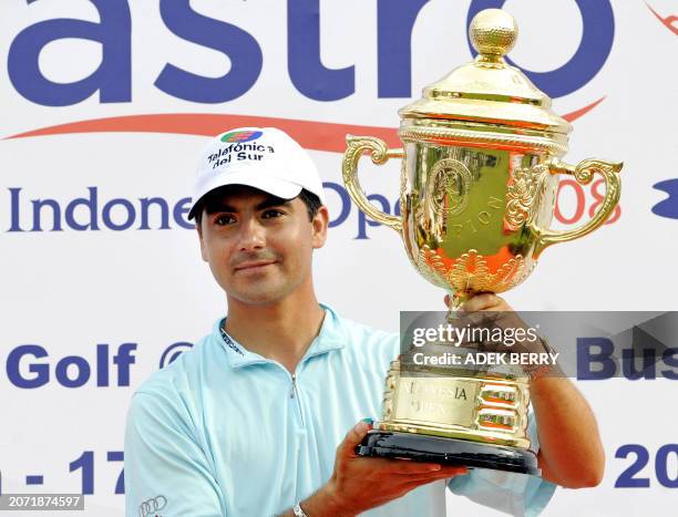 Felipe Aguilar of Chile holds up the winner's trophy following his victory in the Enjoy Jakarta Astro Indonesia Open golf tournament in Tangerang on...