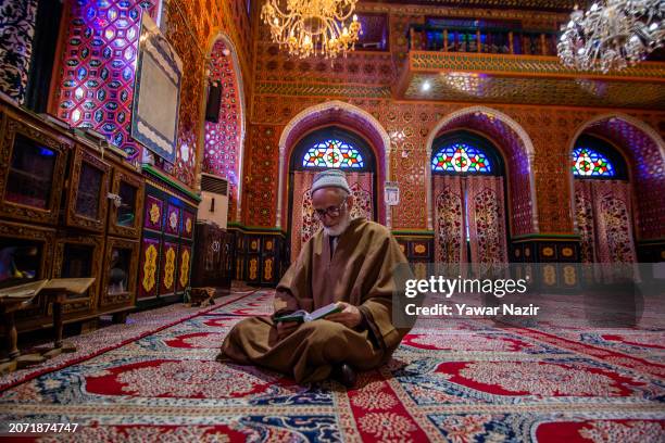 An elderly Kashmiri Muslim recites Holy Quran, on the first day of the holy Islamic month of Ramadan, at the Dastgeer Sahib shrine, dedicated to the...