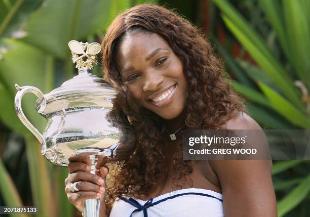 Serena Williams of the US poses with the winner's trophy in the players' garden following her victory over Maria Sharapova of Russia in the women's...