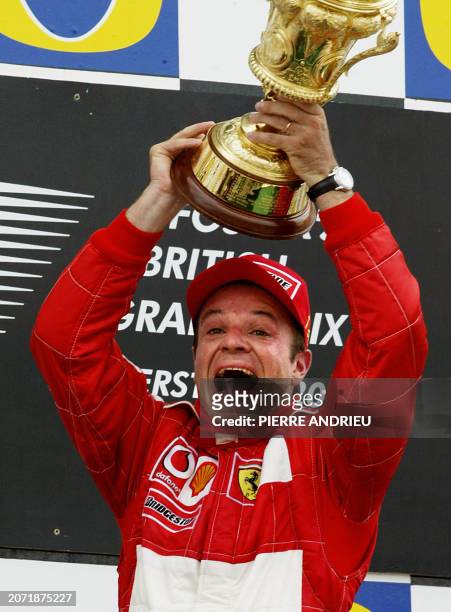 Brazilian Ferrari driver Rubens Barrichello holds his trophy on the podium of the Silverstone racetrack, 20 July 2003, after the British Formula One...