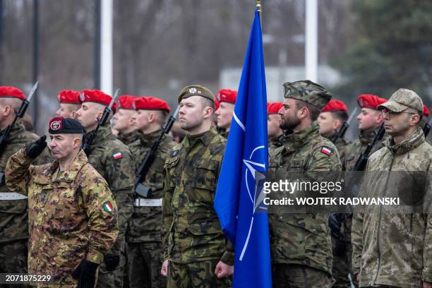 Polish soldier holds a NATO flag as he takes part in a ceremony commemorating the 25th anniversary of Poland joining NATO, on March 12, 2024 in...