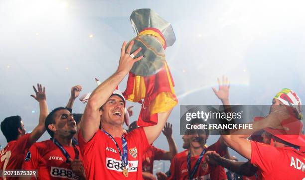 Sevilla's Spanish defender Aitor Ocio Coro holds the trophy as they win the UEFA Cup final football match against Espanyol on penalties at Hampden...