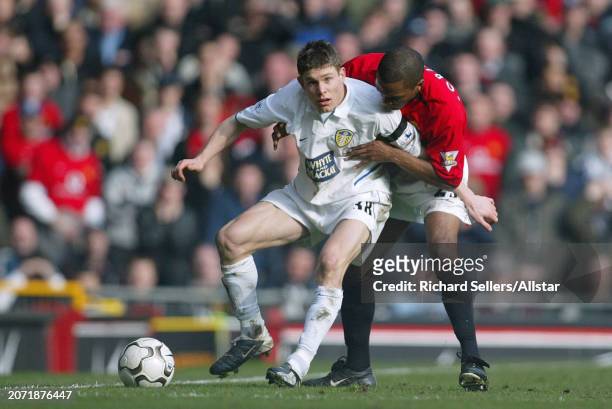 February 21: James Milner of Leeds United and Quinton Fortune of Manchester United challenge during the Premier League match between Manchester...