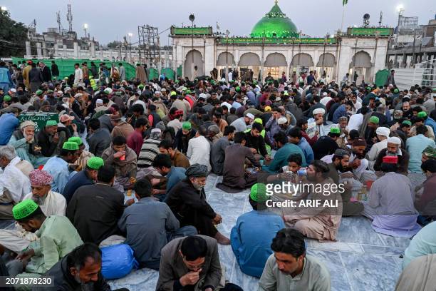 Muslim devotees break their fast at the Data Darbar shrine on the first day of the Islamic holy month of Ramadan, in Lahore on March 12, 2024.