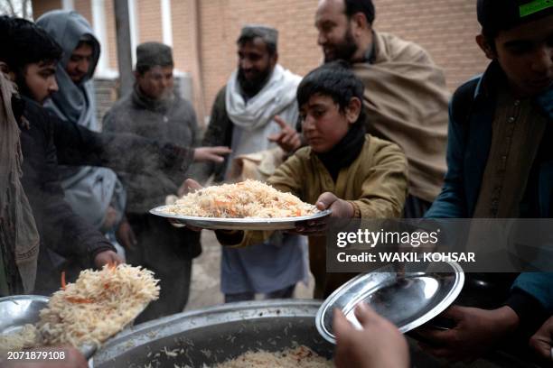 Loacal Afghan people distribute food to the Muslim devotees ahead of Iftar during the Islamic holy month of Ramadan at the Wazir Akbar Khan mosque in...