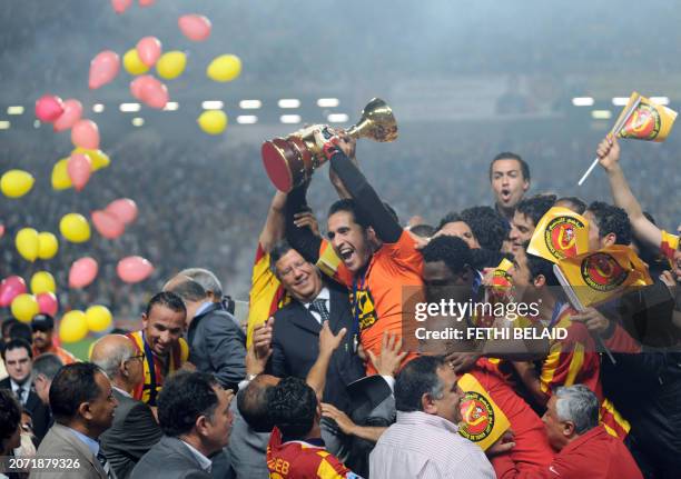 Tunisian Esperance de Tunis team captain Hamdi Kasraoui and his teammate cheer with a trophee during their Arab Champions League football match on...