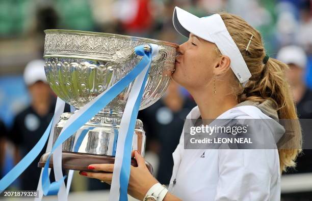 Caroline Wozniacki of Denmark poses with the trophy after beating Virginie Razzano of France in the women's final of the WTA grasscourt tournament at...