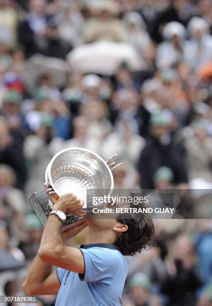 Swiss Roger Federer holds up the trophy after winning against Swedish player Robin Soderling during their French Open tennis men's final match on...