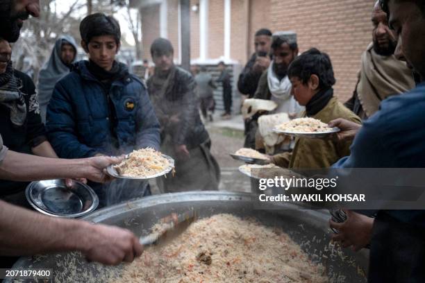 Loacal Afghan people distribute food to the Muslim devotees ahead of Iftar during the Islamic holy month of Ramadan at the Wazir Akbar Khan mosque in...