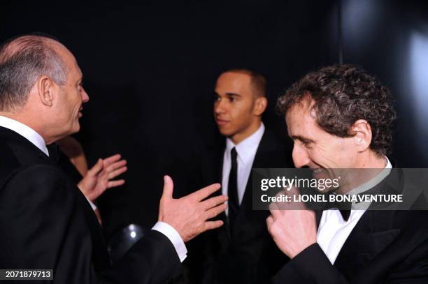 McLaren Mercedes' British driver Lewis Hamilton chats with McLaren's head Ron Dennis and French former Formula 1 champion Alain Prost in Paris on...