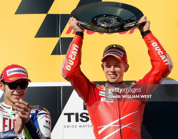 Casey Stoner of Australia holds up the trophy as second-placed Valentino Rossi of Italy applauds after winning the Australian MotoGP at the Phillip...