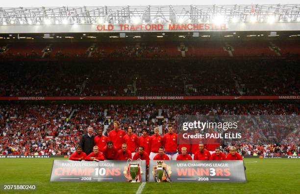 Manchester United players parade the Champions League and English Premiership trophies ahead of their pre-season friendly football match against...