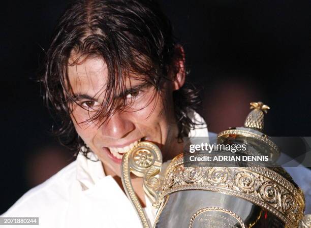 Spain's Rafael Nadal bites his trophy after defeating Switzerland's Roger Federer during their final tennis match of the 2008 Wimbledon championships...