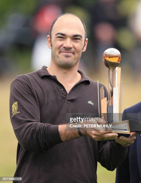 Gregory Havret of France holds up the Johnnie Walker Cup Trophy after winning with a 14 under par to win The Johnnie Walker Championship at...