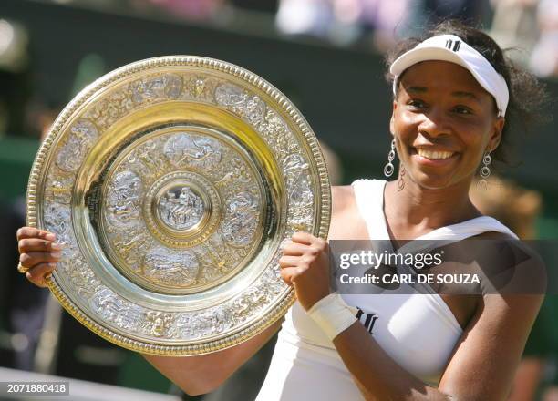 Venus williams poses holding her trophy after beating her sister Serena during their final tennis match of the 2008 Wimbledon championships at The...