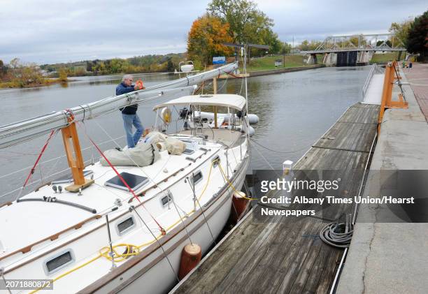 Pierre Landry of Montreal, Canada fixes something on his vessel's mast while navigating the Erie Canal during a vacation with his wife in the Bahamas...
