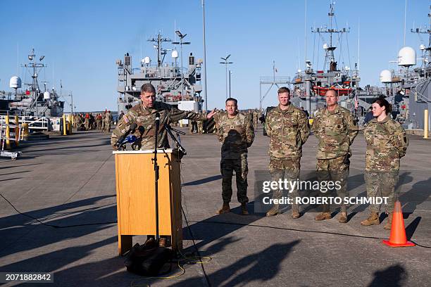 Army Brigadier General Brad Hinson speaks to members of the press near four US Army ships before departure from the Joint Base Langley-Eustis during...