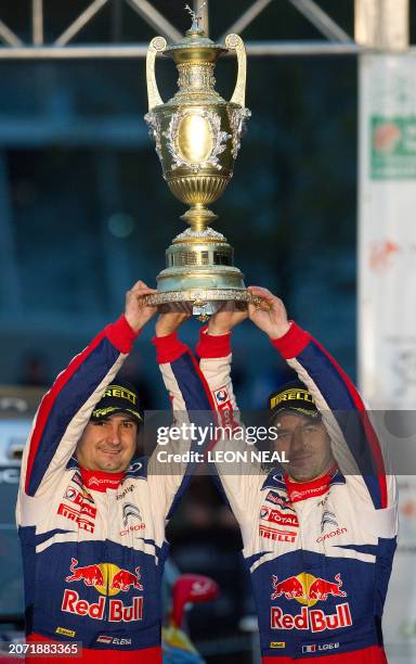 Sebastien Loeb of France and co-driver Daniel Elena of Monaco hold up the RAC cup after winning the WRC Rally of Great Britain and World Championship...