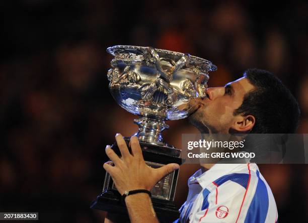 Novak Djokovic of Serbia kisses the winner's trophy after he beat Andy Murray of Britain in their men's singles final on the fourteenth day of the...