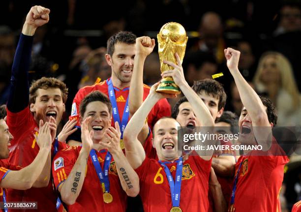 Spain's midfielder Andres Iniesta raises the trophy as Spain's national football team players celebrate winning the 2010 World Cup football final...