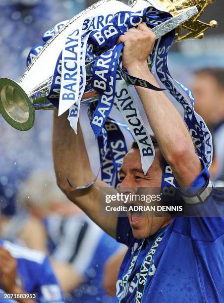 Chelsea's English defender and captain John Terry celebrates with the Premier League trophy after they win the title with a 8-0 victory over Wigan...